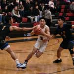 Juneau-Douglas High School: Yadaa.at Kalé senior Alwen Carrillo (3) is defended by Kodiak senior Aron Paguio (1) and junior Bubba Basuel (2) during the Crimson Bears 75-50 win over the Bears on Saturday at the George Houston Gymnasium. (Klas Stolpe/For the Juneau Empire)