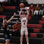 Juneau-Douglas High School: Yadaa.at Kalé junior Gavin Gerrin (1) scores from past the arc over Kodiak junior Mac Abellera (00) during the Crimson Bears 75-50 win over the Bears on Saturday at the George Houston Gymnasium. (Klas Stolpe/For the Juneau Empire)