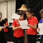 Kasnéiyeek Karmyn Jackson and Awasti Lizzie George-Frank (center) review their remarks about what they like about the Tlingit Culture, Language and Literacy Program during a presentation to the audience at a community conversation focusing on the Juneau School Districts budget crisis at Elizabeth Peratrovich Hall on Thursday night. (Mark Sabbatini / Juneau Empire)