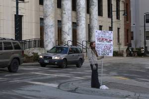 Eric Bookless holds up a protest sign regarding the situation in Gaza while standing in a traffic median next to the Alaska State Capitol on Wednesday. Gov. Mike Dunleavy introduced a bill during the day that would increase the penalties and definitions of illegal protests, although Bookless actions do not appear to fall under its provisions. (Mark Sabbatini / Juneau Empire)