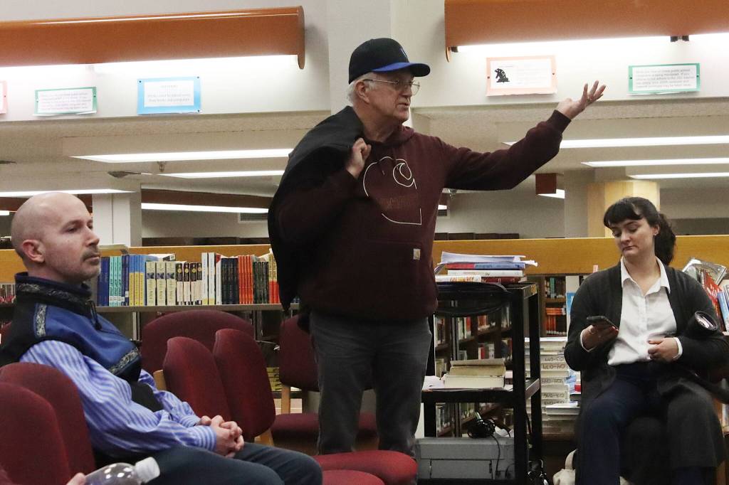 Charles Van Kirk, one of many Juneau residents testifying a seven-hour Board of Education meeting that ended after midnight on Friday, challenges members afterward regarding what he called an illegal vote by them to conceptually approve a consolidation plan. (Mark Sabbatini / Juneau Empire)
