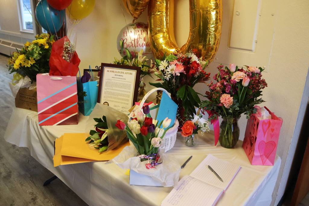 Gifts, flowers, cards and a legislative citation for Jirdes Winther Baxter are placed on a table at the entrance of the Juneau Yacht Club during her 100th birthday celebration Saturday. (Mark Sabbatini / Juneau Empire)