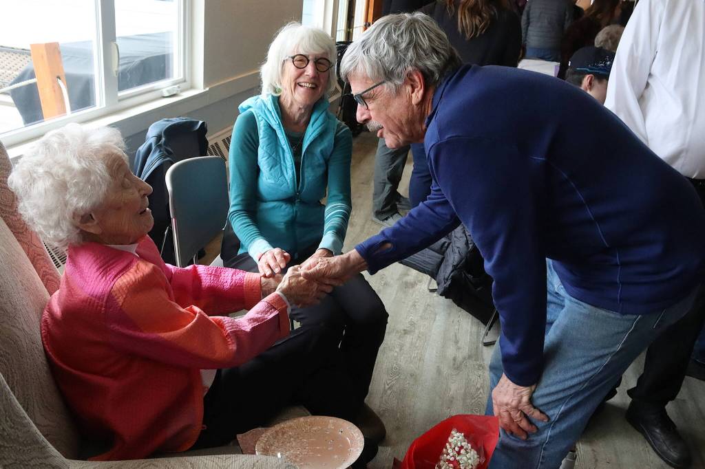Jirdes Winther Baxter accepts birthday greetings from Bob Engelbrecht and Jan McPhetres during Baxters 100th birthday celebration Saturday at the Juneau Yacht Club. (Mark Sabbatini / Juneau Empire)