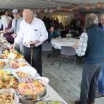 Guests at Jirdes Winther Baxters 100th birthday party help themselves to the buffet at the Juneau Yacht Club on Saturday. (Mark Sabbatini / Juneau Empire)