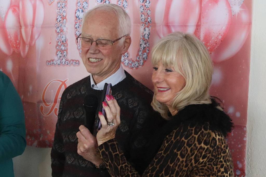 Fred Baxter and Berta Winther accept a call from U.S. Sen. Lisa Murkowski congratulating Jirdes Winther Baxter during her 100th birthday celebration at the Juneau Yacht Club on Saturday. (Mark Sabbatini / Juneau Empire)