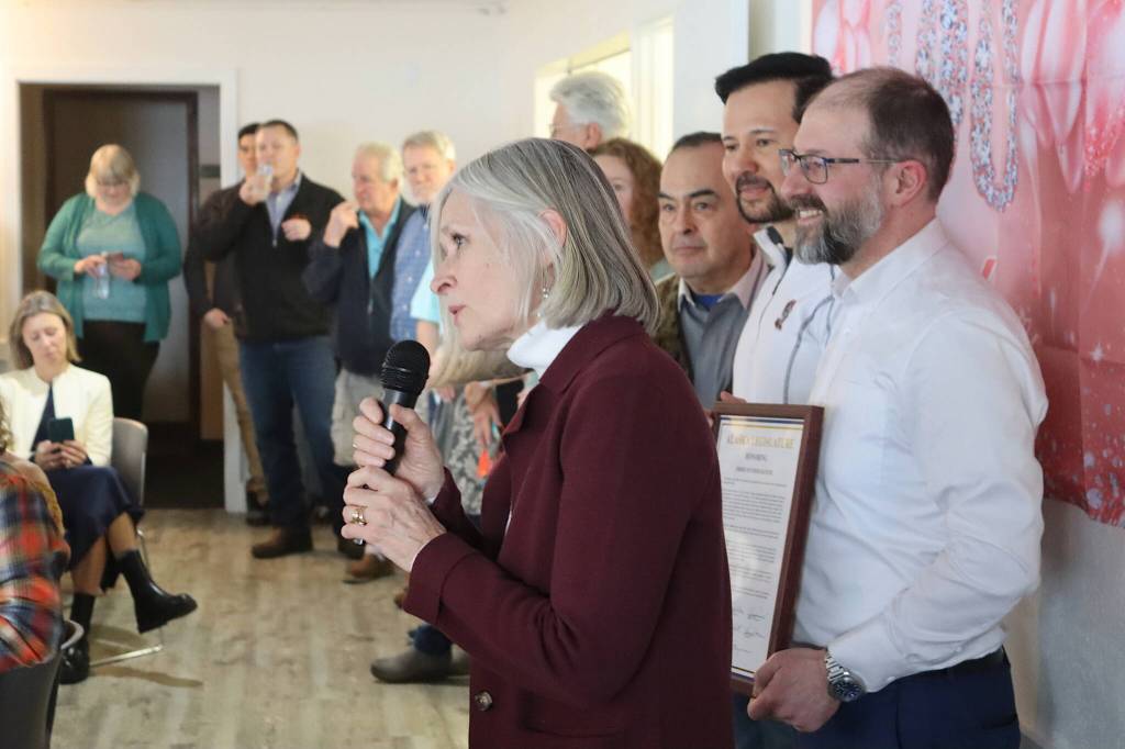State Rep. Andi Story, D-Juneau congratulates Jirdes Winther Baxter during her 100th birthday celebration at the Juneau Yacht Club on Saturday. Other legislators behind Story attending the party and offering congratulations include, from right to left, Sen. Jesse Kiehl, D-Juneau, Richard Foster, D-Nome, and Sen. Donny Olson, D-Golovin. (Mark Sabbatini / Juneau Empire)