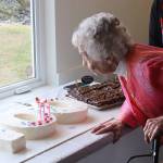 Jirdes Winther Baxter blows out the candles on her cake during her 100th birthday celebration Saturday at the Juneau Yacht Club. (Mark Sabbatini / Juneau Empire)