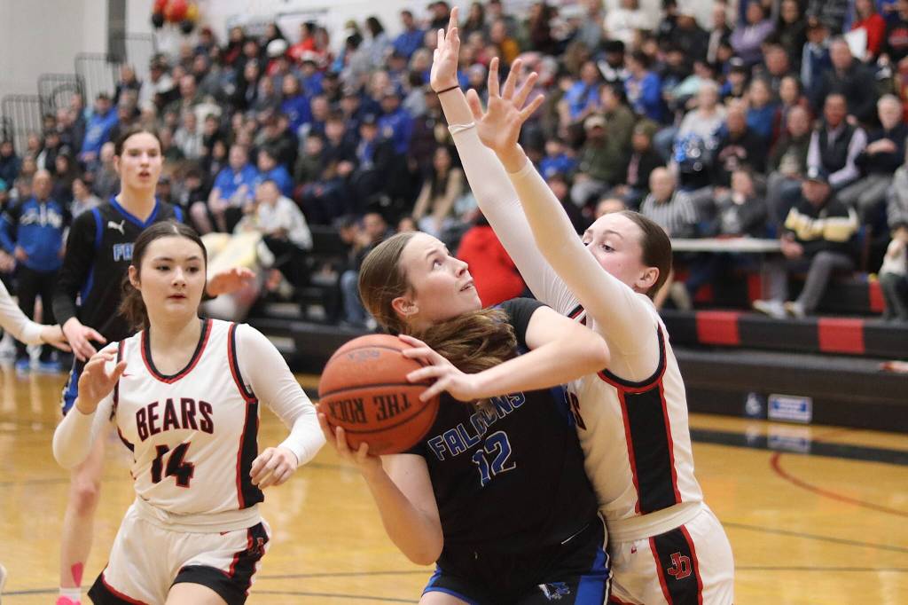 Thunder Mountain High Schools Bergen Erickson tries to get a shot past Juneau-Douglas High School: Yadaa.at Kalés Chloe Casperson and Layla Tokuoka (#14) during Saturdays game at JDHS. (Mark Sabbatini / Juneau Empire)