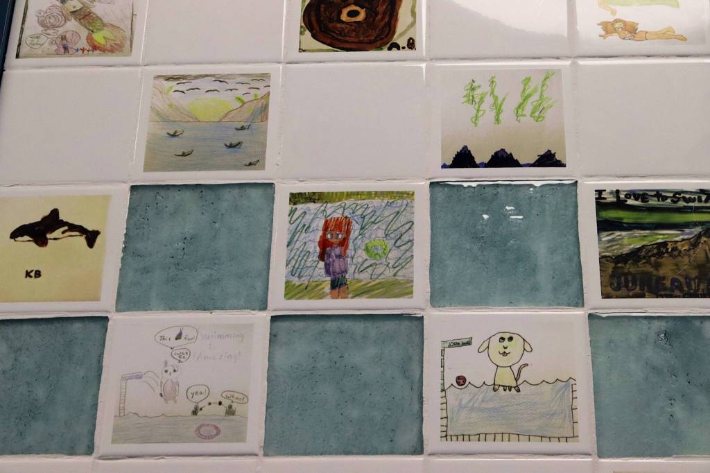 Some of the 288 tiles featuring art by local children that line the upper walls of the lobby at the renovated Augustus G. Brown Swimming Pool. Half of the tiles are digitalized images of Juneau that second- and third-grade students painted on tiles that in 1999 were placed in the now-remodeled locker room showers, while the other half are new drawings by local students of their favorite memories of the pool. (Mark Sabbatini / Juneau Empire)