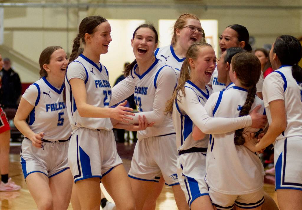 The Thunder Mountain High School Falcons girls basketball team celebrate their 56-49 win over the Juneau-Douglas High School: Yadaa.at Kalé Crimson Bears in the championship game of the Alaska Airlines Region V 4A Basketball Tournament on Friday at Mt. Edgecumbe High Schools B.J. McGillis Gymnasium in Sitka. (James Poulson/Daily Sitka Sentinel)