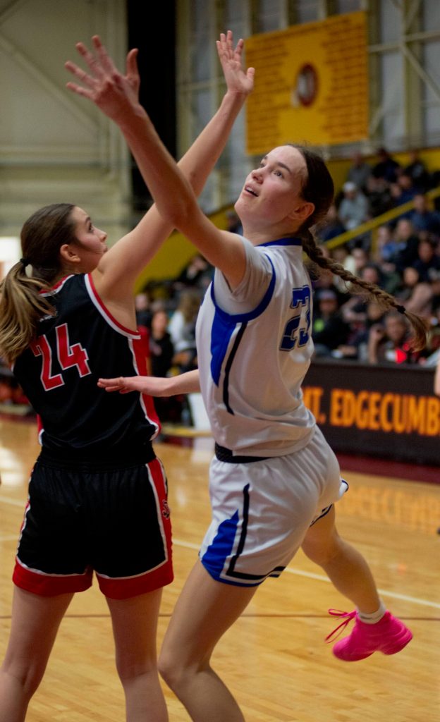 Thunder Mountain junior Cailynn Baxter (23) is defended by Juneau-Douglas High School: Yadaa.at Kalé senior Mila Hargrave (24) during the Falcons 56-49 win over the Crimson Bears in the championship game of the Alaska Airlines Region V 4A Basketball Tournament on Friday at Mt. Edgecumbe High Schools B.J. McGillis Gymnasium in Sitka. (James Poulson/Daily Sitka Sentinel)