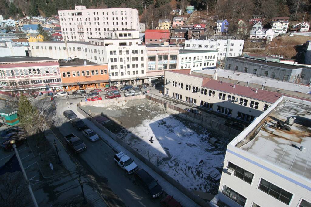 For several years the site of the burned C.W. Young store was an idle eyesore. Here a raven is silhouetted against the snow-covered ground as it flies above the pit. The space would be developed into the Walter Soboleff Building. Dr. Soboleff was of the Raven moiety. (Photo by Brian Wallace)