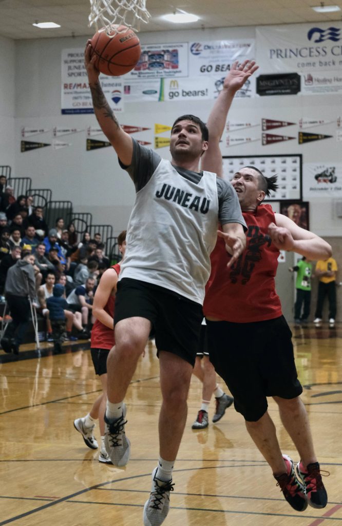 Juneaus Stewart Conn scores past Hydaburgs George Peratrovich during Thursdays B Bracket semifinal in the Juneau Lions Club 74th Annual Gold Medal Basketball Tournament last year at Juneau-Douglas High School: Yadaa.at Kalé. (Klas Stolpe/For the Juneau Empire)