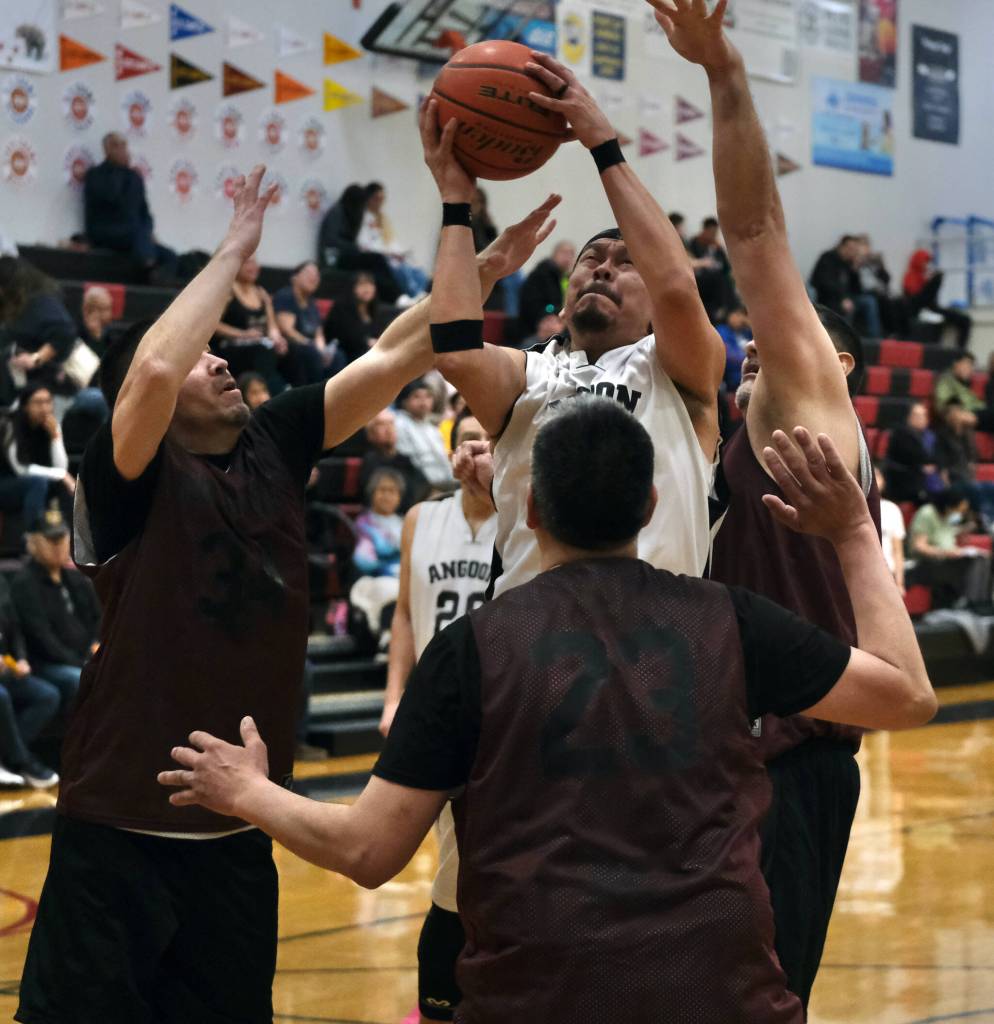 Angoons Travis See powers up a shot against Hoonahs Kamal Lindoff, Albert Hinchman and Michael Mills during the Gold Medal tournament on Wednesday, March 22, 2023, at Juneau-Douglas High School: Yadaa.at Kalé. (Klas Stolpe/For the Juneau Empire)