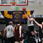 Filcoms Alex Heumann (24) scores past Klukwans Paul Carrington (3) and Brian Friske (32) during the C Bracket Championship game of the Gold Medal Basketball Tournament on Saturday, March 25, 2023, at Juneau-Douglas High School: Yadaa.at Kalé. (Klas Stolpe/For the Juneau Empire)