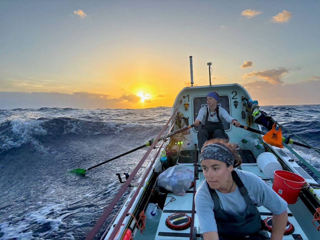 Lauren Shea, foreground, and Noelle Helder row into the sunset as they cross the Atlantic Ocean as part of a four-woman team. (Photo courtesy Noelle Helder)