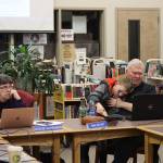 Juneau Board of Education President Deedie Sorensen (left) and Vice President Emil Mackey, holding his son Emil Mackey IV, listen to discussion about next years budget for the school district during a meeting Thursday night at Juneau-Douglas High School: Yadaa.at Kalé. (Mark Sabbatini / Juneau Empire)