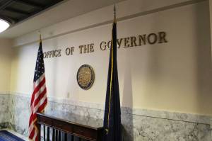 Flags flank the entrance to Gov. Mike Dunleavys office at the Alaska State Capitol on Thursday. (Ashlyn OHara/Peninsula Clarion)