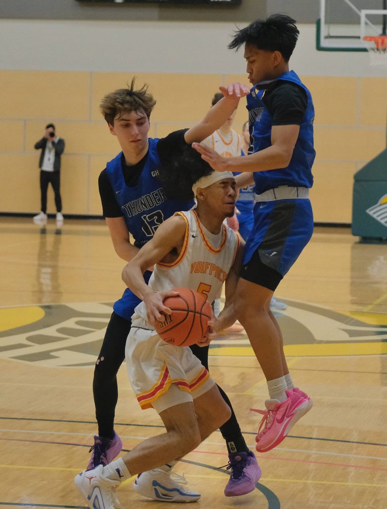 Thunder Mountain seniors Kasen Ludeman (13) and Joren Gasga pressure West Valley senior Jamari Sims (5) during the Falcons 53-51 overtime win against the Wolfpack in the 2024 ASAA March Madness Alaska 4A Boys Basketball State Championships on Wednesday at Anchorages Alaska Airlines Center. (Klas Stolpe for the Juneau Empire)