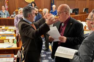 Rep. Andrew Gray, D-Anchorage, gestures with his hands as he talks to Rep. Kevin McCabe, R-Big Lake, about an amendment to raise the states age of consent on Friday in the Alaska House of Representatives. (Photo by James Brooks/Alaska Beacon)