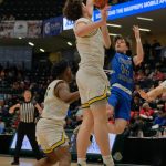 Thunder Mountain senior Samuel Lockhart (14) gets a shot off over Service seniors Mackeenan Morgan (5) and Toby Howard (35) during the Falcons 48-45 overtime win against the Cougars in a semifinal at the 2024 ASAA March Madness Alaska 4A Boys Basketball State Championships on Friday at Anchorages Alaska Airlines Center. (Klas Stolpe / For the Juneau Empire)