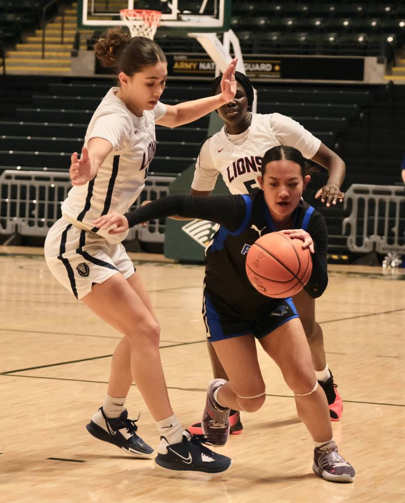 Thunder Mountain High School senior Mikah Carandang (4) dribbles through a half court press by Mountain City seniors Morgan Maldonado and Nyamach Mathot during the Falcons 52-37 loss to the Lions in the 3rd/5th place game of the 2024 ASAA March Madness Alaska 4A Girls Basketball State Championships on Saturday at Anchorages Alaska Airlines Center. (Klas Stolpe / For the Juneau Empire)
