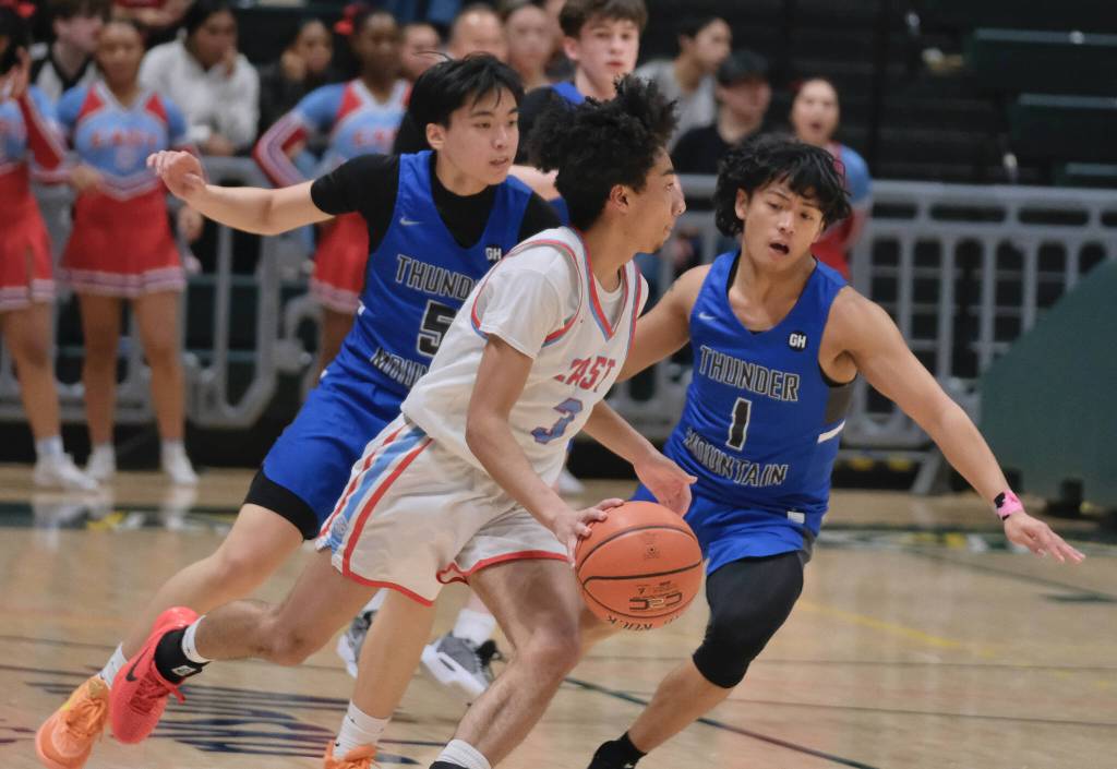 Thunder Mountain seniors TJ Guevarra (5) and Lance Nierra (1) defend East senior Michael George (3) during the Falcons 60-34 loss to the Thunderbirds in the title game of the 2024 ASAA March Madness Alaska 4A Boys Basketball State Championships on Saturday at Anchorages Alaska Airlines Center. (Klas Stolpe / For the Juneau Empire)