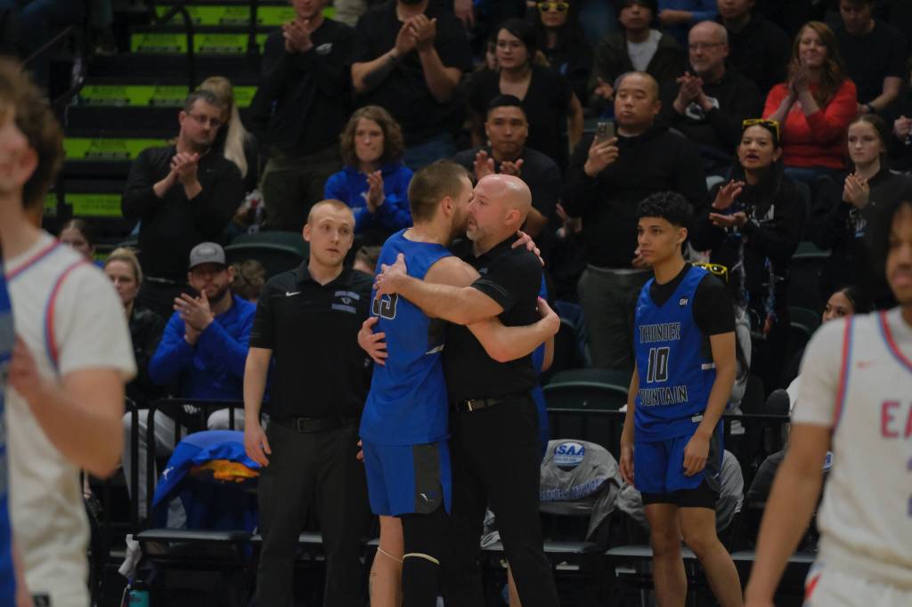Thunder Mountain coach John Blasco hugs senior Thomas Baxter (33) after subbing him out at the end of the Falcons 60-34 loss to the Thunderbirds in the title game of the 2024 ASAA March Madness Alaska 4A Boys Basketball State Championships on Saturday at Anchorages Alaska Airlines Center. (Klas Stolpe / For the Juneau Empire)