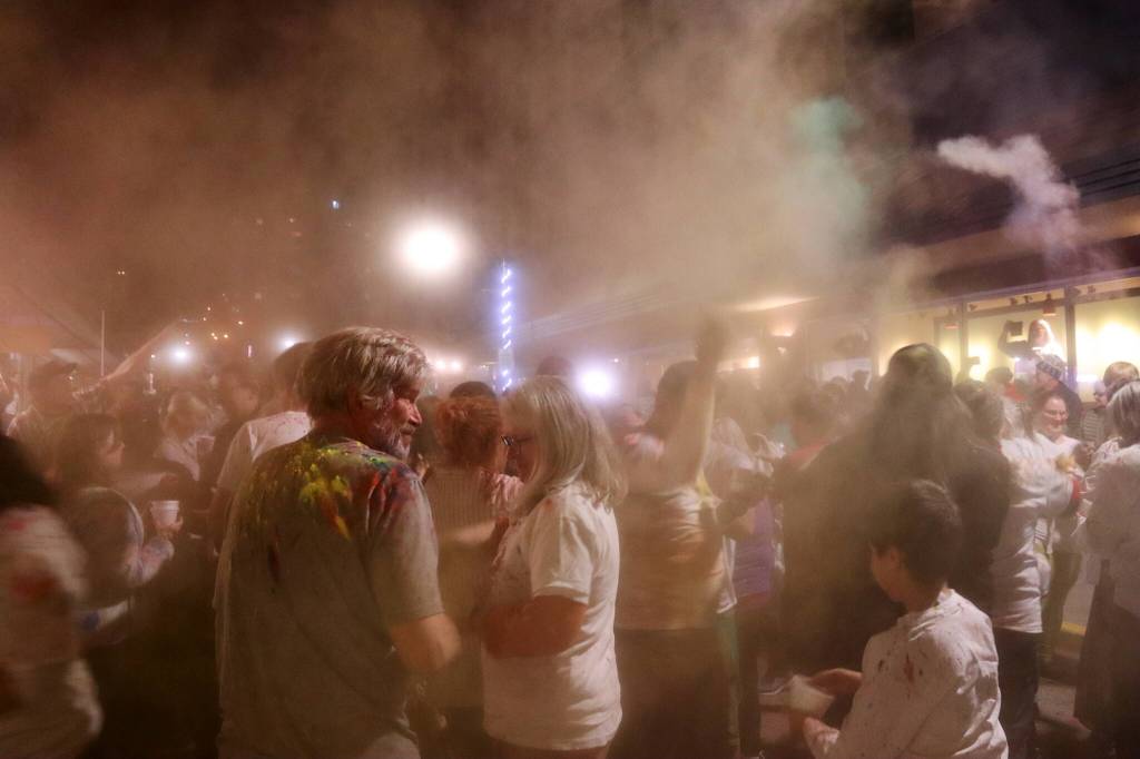 The air becomes hazy at the height of the tossing of colors during the Holi festival Monday night in downtown Juneau. (Mark Sabbatini / Juneau Empire)