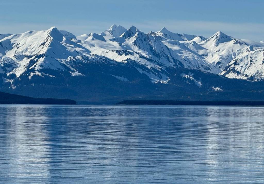 Sun on the Chilkats reflects on Stevens Passage on March 21. (Photo by Denise Carroll)
