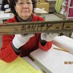 This Feb. 2, 2011, photo shows Niejse Steinkruger at the Alaska state archives in Juneau, Alaska, displaying a book of old court records that included sanity hearings. Steinkruger and other volunteers have spent years digging through old records to identify about 5,500 Alaskans who were committed to a mental hospital in Oregon before Alaska gained statehood. (Roger Brunner via AP)
