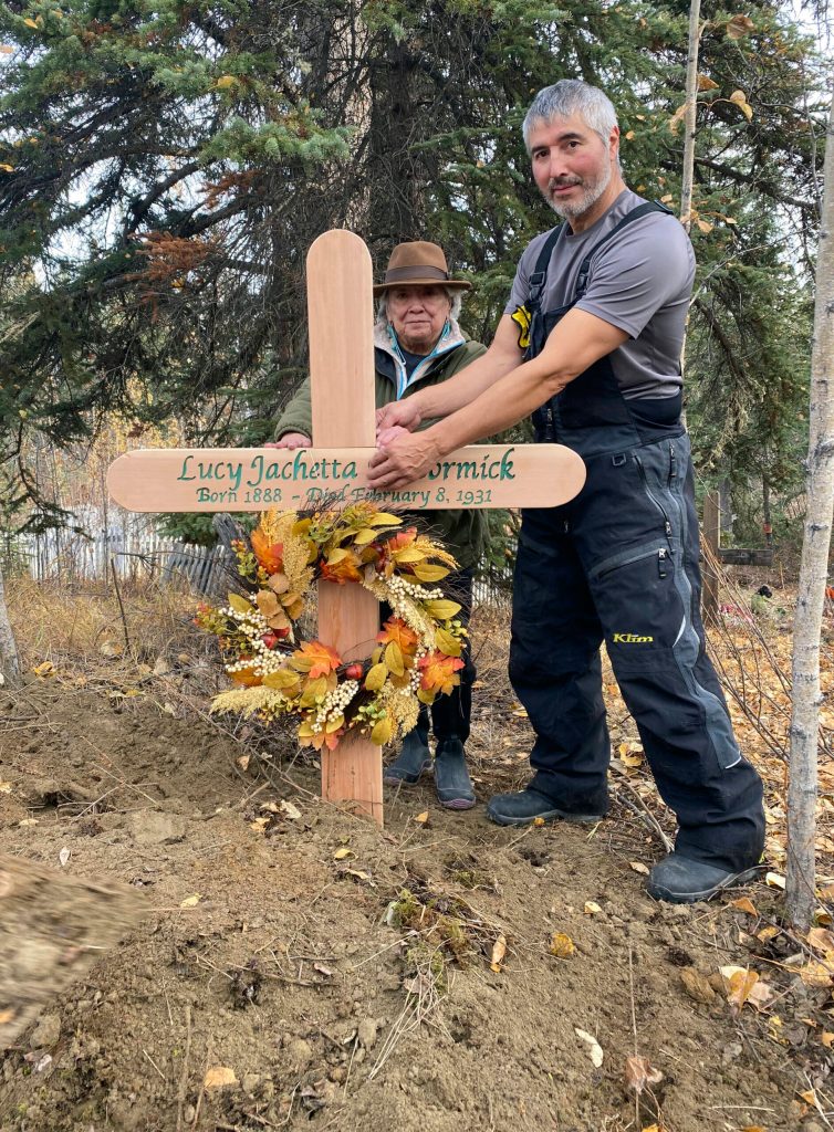 In this Sept. 29, 2023, photo, Brian Cruger holds the cross made for the grave of his great-grandmother, Lucy Pitka McCormick, and with him is McCormicks granddaughtger, Kathleen Carlo, during a reburial ceremony in Rampart, Alaska. Pitka was one of the Lost Alaskans sent to a mental hospital in the 1930s. Her grave was recently discovered, and family members brought her back to Alaska for a proper burial. (Photo by Wally Carlo via AP).