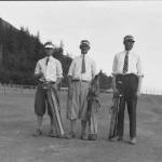 Governor George Parks (right), AELPs manager William Pullen (center) and an unidentified man (left) stand on the barren Million Dollar Golf Course made atop the waste rock from the A-J mine. There was no grass on fairways or greens. (ASL-P87-1261)