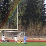 A rainbow shines down on Juneau-Douglas High School: Yadaa.at Kalé players as the team scores a first-half goal against Thunder Mountain High School during the teams opening game of the 2024 season at TMHS. (Mark Sabbatini / Juneau Empire)
