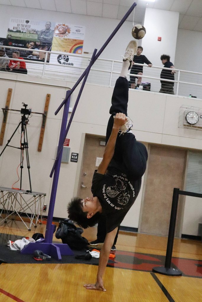Matthew Chagluak extends his body to execute an Alaskan high kick during the Traditional Games at Juneau-Douglas High School: Yadaa.at Kalé on Saturday. (Mark Sabbatini / Juneau Empire)