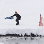 Charles Gueriera tries to cross the pond at the Slush Cup with Tango Two, a stuffed whale named after a humpback whale calf that died last summer after apparently being hit by a large boat, during the last day of the season at Eaglecrest Ski Area on Sunday. (Mark Sabbatini / Juneau Empire)