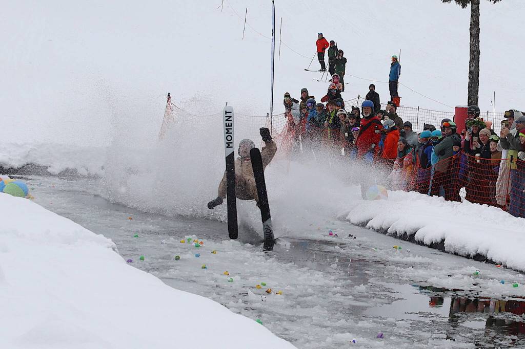 Brett Weideman wipes out while trying to cross the pond during his first Slush Cup at Eaglecrest Ski Area on Sunday. (Mark Sabbatini / Juneau Empire)