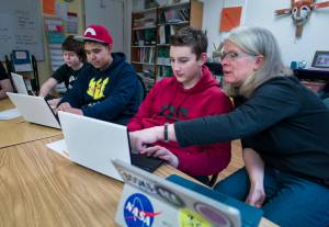 Math Specialist Brenda Taylor helps eighth-graders Fisher Lee, right, and Jorge Cordero, center, and sixth-grader Joshua Kessler with their coding project at the Juneau Community Charter School on Wednesday, Jan. 10, 2018. The school celebrated its 20th anniversary that year. (Michael Penn / Juneau Empire file photo)