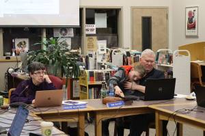 Juneau Board of Education President Deedie Sorensen (left) and Vice President Emil Mackey, holding his son Emil Mackey IV, listen to discussion about next years budget for the school district during a meeting March 14 at Juneau-Douglas High School: Yadaa.at Kalé. Both are the targets of recall petitions expected to begin circulating this week. (Mark Sabbatini / Juneau Empire)