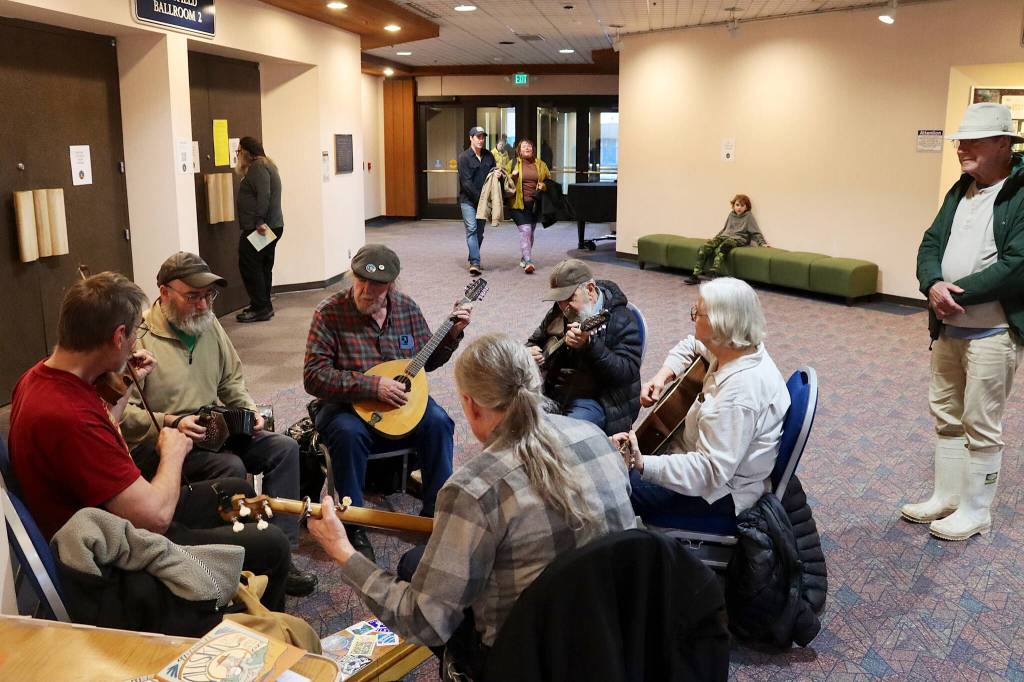 Musicians perform an impromptu set in the hallway outside the main ballroom at Centennial Hall during the opening night of the 49th annual Alaska Folk Festival on Monday. (Mark Sabbatini/Juneau Empire)