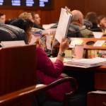 Rep. Genevieve Mina, D-Anchorage, stares at a pile stack of budget amendments on Tuesday. (James Brooks/Alaska Beacon)