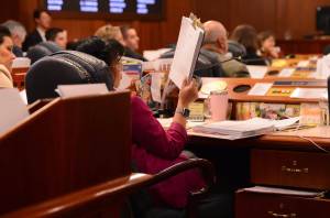 Rep. Genevieve Mina, D-Anchorage, stares at a pile stack of budget amendments on Tuesday. (James Brooks/Alaska Beacon)