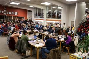 A crowd overflows the library at Juneau-Douglas High School: Yadaa.at Kalé on Feb. 22 as school board members meet to consider proposals to address the Juneau School Districts budget crisis. (Mark Sabbatini / Juneau Empire file photo)