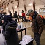 Greg Martini, a staff member at the citys cold weather emergency shelter, offers farewells and bags of food to people departing the shelter early Tuesday morning, the final day of operation for the facility until this fall. (Mark Sabbatini / Juneau Empire)
