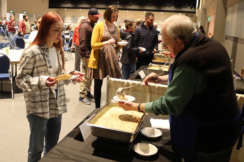Willis Kirkpatrick serves soup to Jamie Quinto during the Empty Bowls fundraiser on behalf of the Glory Hall at Centennial Hall on Sunday. (Mark Sabbatini / Juneau Empire)