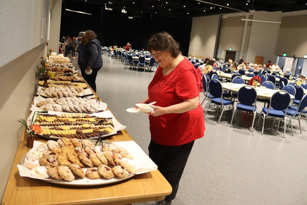 Bonnie Berg examines the dessert table at the Empty Bowls fundraiser at Centennial Hall on Sunday. (Mark Sabbatini / Juneau Empire)