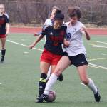 Juneau-Douglas High School: Yadaa.at Kalés Cadence Plummer and Thunder Mountain High Schools Randy Stichert fight for the ball during Mondays game at Adair-Kennedy Field. (Mark Sabbatini / Juneau Empire)