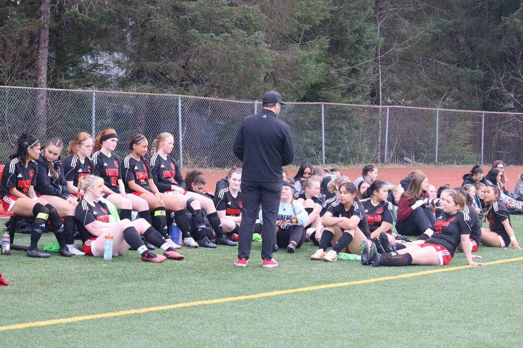 Matt Dusenberry, head coach of the girls soccer team at Juneau-Douglas High School: Yadaa.at Kalé, addresses the team at halftime of its game against Thunder Mountain High School on Monday at Adair-Kennedy Field. (Mark Sabbatini / Juneau Empire)