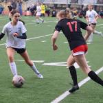 Thunder Mountain High Schools Ella Orsborne tries to keep the ball away from Juneau-Douglas High School: Yadaa.at Kalés Alyssa Travis during Mondays game at Adair-Kennedy Field. (Mark Sabbatini / Juneau Empire)
