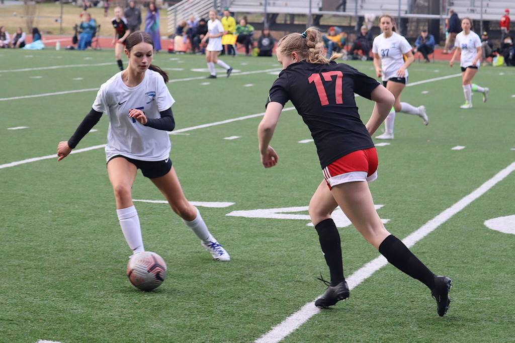 Thunder Mountain High Schools Ella Orsborne tries to keep the ball away from Juneau-Douglas High School: Yadaa.at Kalés Alyssa Travis during Mondays game at Adair-Kennedy Field. (Mark Sabbatini / Juneau Empire)